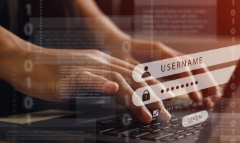 Hands typing on a laptop keyboard with digital login screen overlay showing username and password fields, symbolizing cybersecurity and account protection.