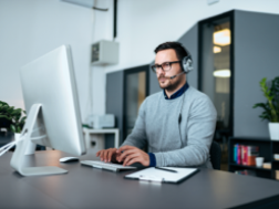 Man in a headset at a large monitor